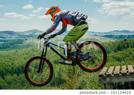 male rider on downhill bike jumping wooden drop, racing DH mountain bike, extreme sport games male rider on downhill bike jumping wooden drop, racing DH mountain bike, extreme sport games 101134618