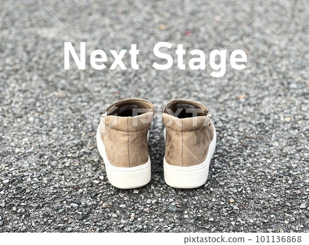Beige shoes and NextStage letters on the asphalt Beige shoes and NextStage letters on the asphalt 101136868
