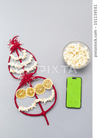 Survakane, Survaknitsa, Survachka with smartphone green chroma key screen. Flat lay with Popcorn, Red White Threads. Bulgarian Traditional Christmas Cornel Tree Twig, World Tree. Vertical plane Survakane, Survaknitsa, Survachka with smartphone green chroma key screen. Flat lay with Popcorn, Red White Threads. Bulgarian Traditional Christmas Cornel Tree Twig, World Tree. Vertical plane 101139581