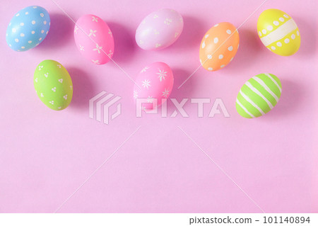 Happy Easter holiday greeting card concept. Colorful Easter Eggs and spring flowers on pastel pink background. Flat lay, top view, copy space. 101140894