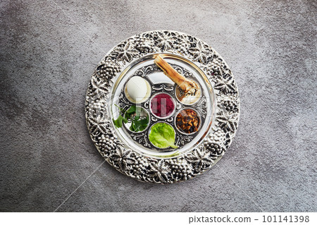 Passover Seder plate with traditional food on grunge background Passover Seder plate with traditional food on grunge background 101141398
