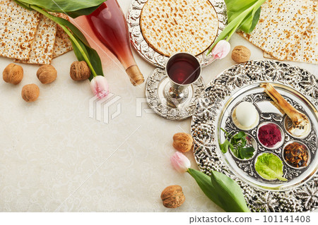 Passover Seder plate with traditional food, walnuts, matza and wine on grunge background 101141408