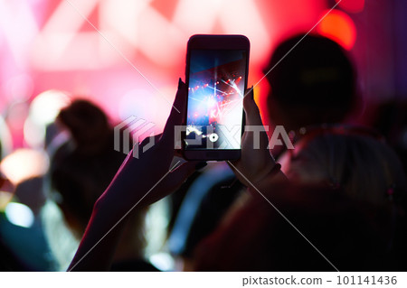 Hand with a phone records live music festival. People taking photographs with smart phone during concert. Hand with a phone records live music festival. People taking photographs with smart phone during concert. 101141436