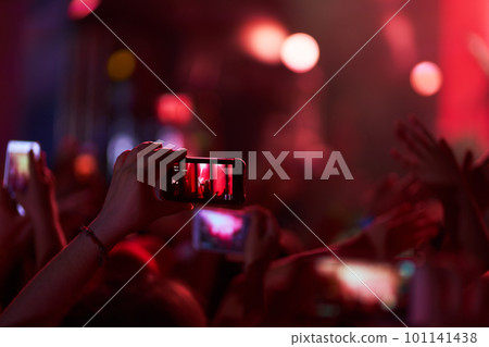 Hand with a phone records live music festival. People taking photographs with smart phone during concert. Hand with a phone records live music festival. People taking photographs with smart phone during concert. 101141438
