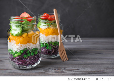 Healthy salad in glass jars on grey wooden table. Space for text Healthy salad in glass jars on grey wooden table. Space for text 101142042