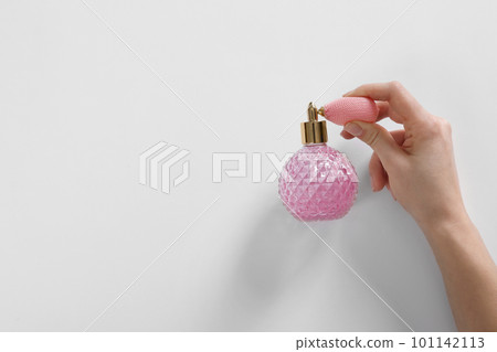 Woman with bottle of perfume on white background, top view. Space for text 101142113