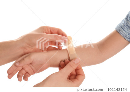 Mother putting sticking plaster onto son's arm on white background, closeup 101142154