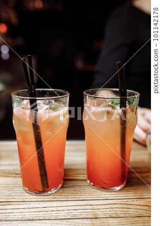 Refreshing grapefruit cocktail with ice and rosemary on a grey background. Refreshing grapefruit cocktail with ice and rosemary on a grey background. 101142178