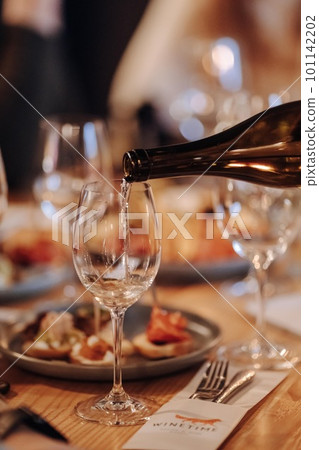 Wine tasting experience in the rustic cellar and wine bar: red wine glass and collection of excellent wines on the background 101142202