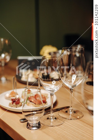 Wine tasting experience in the rustic cellar and wine bar: red wine glass and collection of excellent wines on the background Wine tasting experience in the rustic cellar and wine bar: red wine glass and collection of excellent wines on the background 101142209