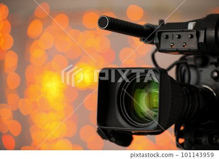 Modern video camera against blurred lights, closeup 101143959