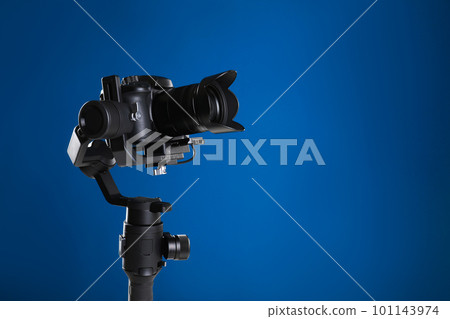 Modern professional video camera on blue background. Space for text 101143974
