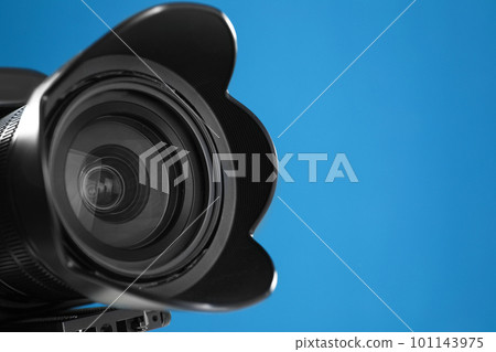 Professional video camera on blue background, closeup view of lens Professional video camera on blue background, closeup view of lens 101143975