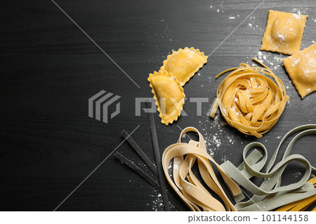 Flat lay composition with different types of pasta on black wooden table 101144158