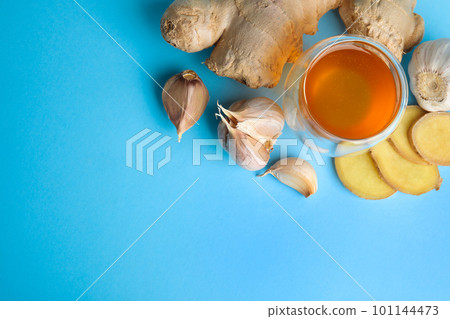 Fresh garlic and other natural cold remedies on light blue background, flat lay. Space for text Fresh garlic and other natural cold remedies on light blue background, flat lay. Space for text 101144473