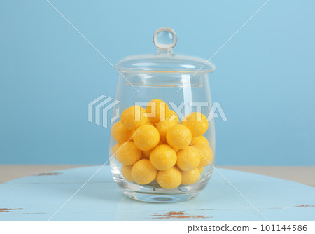 Tasty lemon drops in glass jar on wooden table 101144586