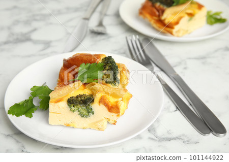 Tasty broccoli casserole served on white marble table Tasty broccoli casserole served on white marble table 101144922