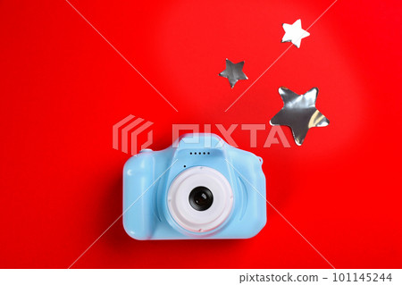 Toy camera and stars on red background, top view 101145244