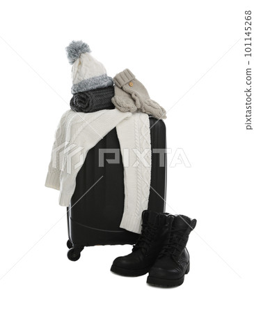Suitcase with warm clothes isolated on white. Winter vacation Suitcase with warm clothes isolated on white. Winter vacation 101145268