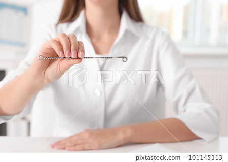 Speech therapist with logopedic probe in clinic, closeup 101145313