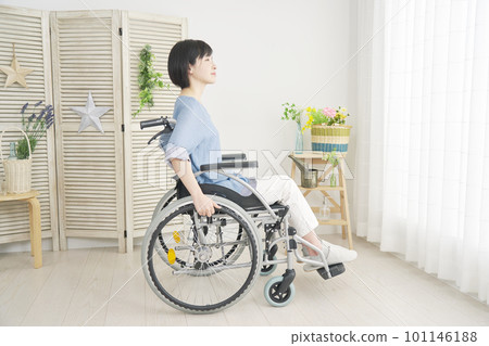 A woman using a wheelchair in the living room, whole body A woman using a wheelchair in the living room, whole body 101146188