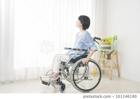 A woman using a wheelchair in the living room, whole body 101146190