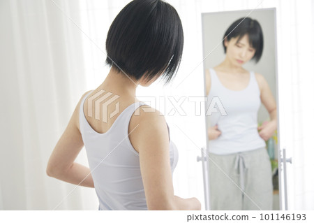 Woman suffering from diet in front of mirror 101146193