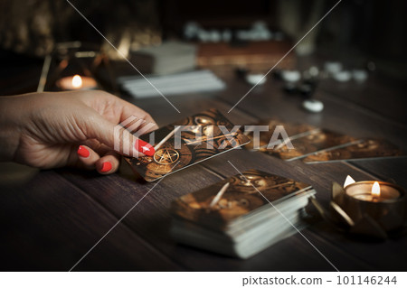 Tarot card reader arranges cards in a card spread. Fortune-telling concept Tarot card reader arranges cards in a card spread. Fortune-telling concept 101146244