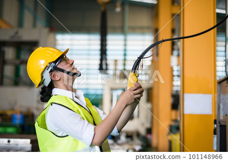 Factory female worker use remote control to lift crane Factory female worker use remote control to lift crane 101148966