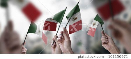 A group of people holding small flags of the Mexico in their hands A group of people holding small flags of the Mexico in their hands 101150971