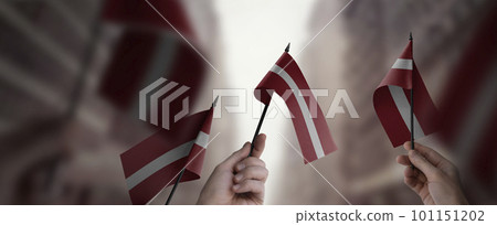 A group of people holding small flags of the Latvia in their hands 101151202