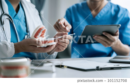 Dentist writing report working with tooth x-ray film model and equipment used in the treatment of dental. 101152708