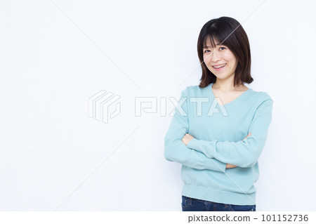 A woman in her thirties thinking with her arms folded and smiling A woman in her thirties thinking with her arms folded and smiling 101152736