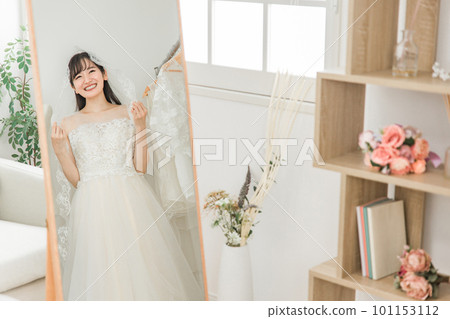 新娘在試穿婚紗和麵紗時看著鏡子 101153112