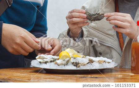 Eating oysters at a street food market. 101153371