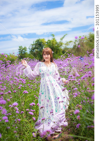 woman wearing a long dress in a field of lavende flowers exudes a relaxed and freedom. Soft and select focus 101153995