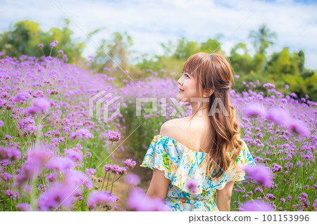 woman wearing a long dress in a field of margaret flowers exudes a relaxed and freedom. Soft and select focus 101153996