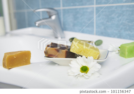 Craft organic soap bars on washbasin in the home bathroom. Purity. Hygiene. Home spa. Skin and body care concept. Craft organic soap bars on washbasin in the home bathroom. Purity. Hygiene. Home spa. Skin and body care concept. 101156347