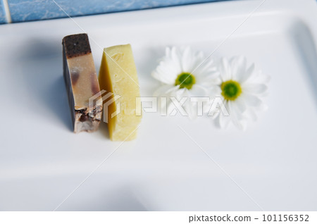 View from above of organic hand made soap bars with grape seeds and coffee beans, near chamomile flowers on wash basin. Natural eco-friendly cosmetics, home spa, body care, hygiene and beauty concept View from above of organic hand made soap bars with grape seeds and coffee beans, near chamomile flowers on wash basin. Natural eco-friendly cosmetics, home spa, body care, hygiene and beauty concept 101156352