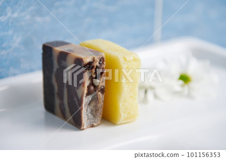 Organic homemade soap bars with coffee beans and essential oils, on a washbasin against a blue marble wall background in home bathroom. Aromatherapy, home spa, skin and body care, hygiene concept 101156353
