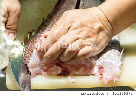 woman cutting fish 101156373
