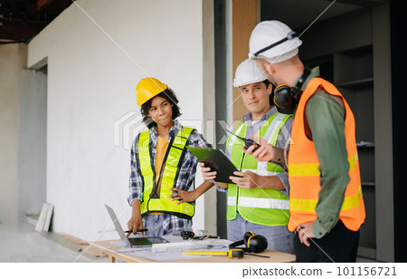 Engineers are discussing data working and laptop or tablet with architectural project at new construction site on big project. 101156721