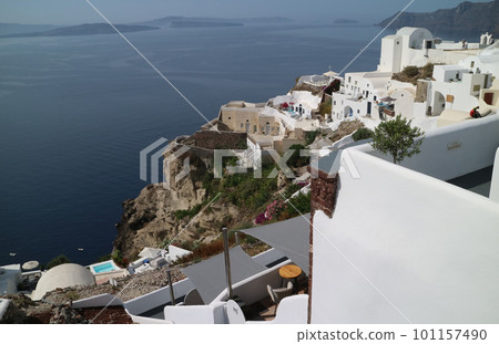 A row of white houses built on the volcanic rocks of a precipitous cliff A row of white houses built on the volcanic rocks of a precipitous cliff 101157490