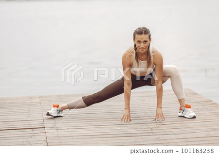 Sports girl by the water. Woman in a summer park. Lady in a sportswear. 101163238