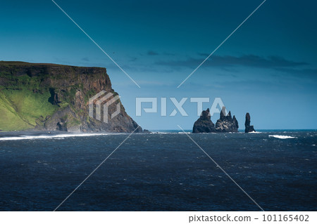 Dramatic moody famous Reynisdrangar rock formation and black Reynisfjara Beach at coastline of Atlantic ocean in Vik, Iceland 101165402