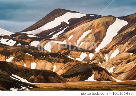 Scenery of majestic volcanic mountain range with snow covered in Fjallabak nature reserve, Icelandic Highlands at Landmannalaugar Scenery of majestic volcanic mountain range with snow covered in Fjallabak nature reserve, Icelandic Highlands at Landmannalaugar 101165483