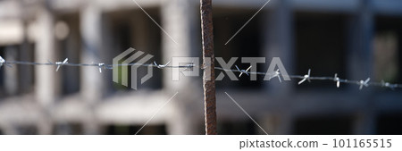 High level barbed wire fence in background of building 101165515