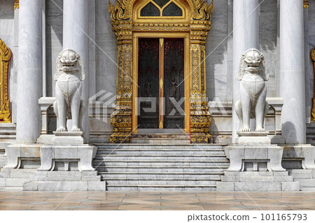 Pair of marble lions in front of the door of Wat Benchamabophit Dusit Wanaram (This temple is known as the Marble Temple) in Bangkok, blue sky and clouds. One of the most beautiful Thailand temples 101165793