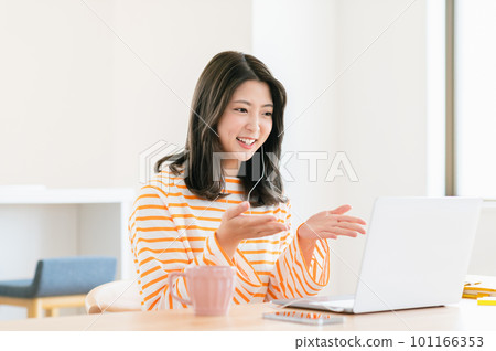 Young woman having a web conference in the living room Young woman having a web conference in the living room 101166353