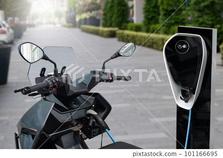Electric scooter with charging station on a city street Electric scooter with charging station on a city street 101166695